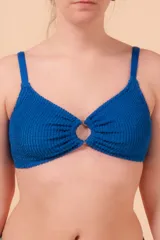 Top de bikini azul con textura, sin aro y con detalle de aro en el centro. Breteles regulables y nudo regulable en la espalda.
