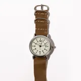 Reloj de pulsera con correa símil cuero negra y esfera blanca con números arábigos.