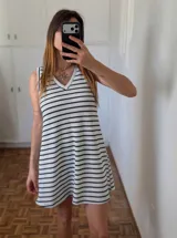 Vestido corto blanco con rayas horizontales negras, escote en V y corte evasé.