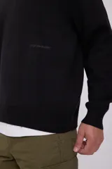 Sweater negro de punto con cuello alto y cierre de cremallera parcial.