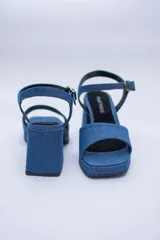 Sandalias de jean con plataforma y taco cuadrado, tira ancha sobre los dedos y pulsera con hebilla al tobillo.
