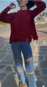 Sweater tejido en lana color borgoña, con cuello redondo y terminación con flecos.