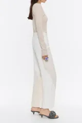 Pantalón vaquero bicolor de corte recto y tiro alto, con cierre frontal y bolsillos redondeados en un diseño contemporáneo.