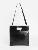 Sobre o clutch de cuero sintético marrón oscuro con textura envejecida. Presenta un diseño plegable con un asa de mano rectangular troquelada en la solapa superior.