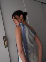 Top celeste y blanco a rayas horizontales, con escote asimétrico y bretel ancho color rosa.