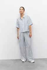 Pantalón largo azul con rayas verticales blancas, de corte amplio, con cintura elastizada y cordón ajustable.