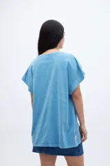 Musculosa celeste con estampado pequeño en el pecho, corte oversize y mangas con dobladillo.