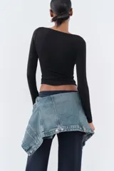 Camiseta negra de algodón con cuello barco y mangas largas.