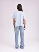 Remera celeste de algodón con estampado de flor y texto "Real View".