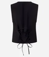 Chaleco negro de sastrería con cuello redondo, cierre frontal con botones metálicos y lazo cruzado en la espalda.