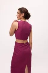 Vestido midi color fucsia, con corte a la cintura y falda tubo con tajo lateral. Presenta un top sin mangas con detalle cut-out en la cintura.