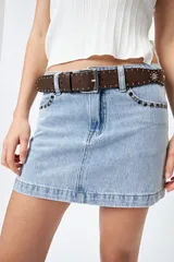 Cinturón negro de cuero sintético con hebilla metálica plateada y apliques de tachas plateadas con forma de corazón y circulares.