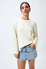 Sweater negro de punto canalé con detalle de trenzado en las mangas y lazo ajustable en el ruedo.
