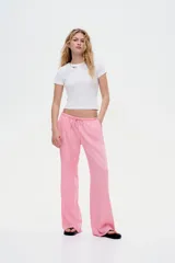 Pantalón de tiro bajo color rosa, confeccionado en tejido liviano con lino en la trama. Presenta elástico revestido y cordón para ajustar en la cintura, bolsillos al bies y piernas rectas.