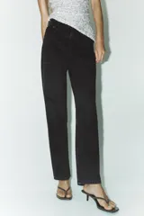 Pantalón de jean celeste, de tiro alto, corte mom fit, con cinco bolsillos y cierre frontal con cremallera y botón metálico.