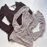 Vestido corto de tejido de punto calado (crochet) con manga larga y escote en V con lazo ajustable en la espalda. Disponible en blanco y marrón oscuro.