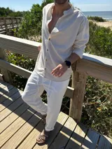 Camisa de lino color beige, con cuello mao y mangas largas. Cierre frontal con botones de madera.