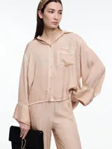 Camisa gris de manga larga confeccionada en viscosa teñida en frío, con efecto gastado. De corte relajado, con bolsillo delantero y puños amplios.