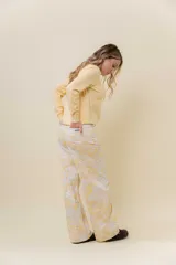 Pantalón de jean de pierna ancha y tiro medio-alto, con estampado suave en tonos amarillos y blancos.