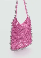 Bolso shopper tejido de color rosa con abalorios plateados en el borde y en las asas.