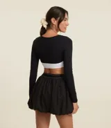 Saco bolero negro de microfibra con mangas largas.