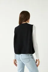 Chaleco de punto grueso color crema, con escote redondo y bordes acanalados.