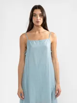 Vestido largo celeste de breteles finos, escote recto y lazos ajustables en los costados.