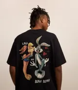 Remera negra de algodón con corte boxy, cuello redondo y mangas cortas. Estampado en la espalda de Lola Bunny besando a Bugs Bunny, con corazones y texto "Lola and Bugs Bunny".