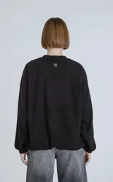 Sweater negro de corte holgado con cuello redondo y mangas largas con puños ajustados.