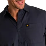 Camisa de popelina verde con cuello abotonado, cierre frontal con botones, bolsillo de parche en el pecho izquierdo, mangas largas con trabillas para enrollar y dobladillo camisero.