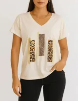 Remera color crudo con cuello en V y estampado de bloques con animal print y detalles dorados.