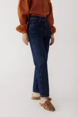 Pantalón de jean azul oscuro, corte mom, con pespuntes rojos y confeccionado en 100% algodón.