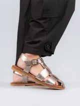 Sandalia de cuero negro con tiras trenzadas y hebilla ajustable.