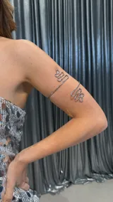 Brazalete plateado de metal con diseño de líneas onduladas.