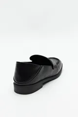 Mocasines negros de símil cuero texturizado, con punta cuadrada y detalle de bordado a tono en la capellada. Taco de 2,5cm.