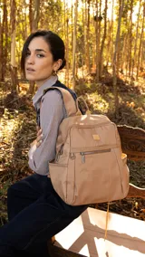 Mochila verde militar de nylon con apertura superior con cierre y tiradores metálicos. Incluye bolsillos internos, bolsillo con cierre metálico al frente, correa corta de mano y correas de galón regulables para colgar en la espalda.