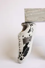 Zapatillas deportivas bajas con estampado animal print de vaca en blanco y marrón.