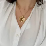Collar dorado con dije en forma de espiral.