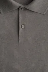 Remera polo color marrón de piqué de algodón, de corte regular fit, con cuello clásico, tapeta de botones, mangas cortas y bajo recto con aberturas laterales.