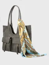Cartera de hombro de ecocuero color gris, con compartimento principal con cierre cremallera, dos bolsillos frontales con solapa y broche imantado, bolsillo interior con cierre y bolsillo trasero con cierre. Incluye un pañuelo estampado como adorno.
