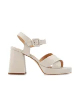 Sandalias de cuero color canela con plataforma y tacón ancho. Tiras cruzadas en el empeine y pulsera ajustable con hebilla en el tobillo.