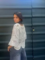 Camisa negra con detalles de crochet color crema, escote en V y mangas 3/4.