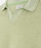 Polo de hombre color verde claro con efecto lavado, cuello polo y manga corta. Presenta un escote en V en la abertura del cuello.