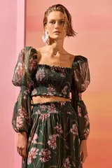 Top corto de gasa color verde con estampado floral, escote recto con elástico, mangas abullonadas con hombreras y elástico en los codos.