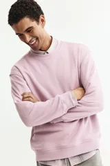 Buzo de tejido de mezcla de algodón de peso medio con interior cepillado suave. Modelo con cuello redondo ribeteado, hombros caídos y remate acanalado ancho en puños y bajo.