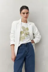 Remera blanca de manga corta con estampado floral en tonos dorados en el frente.