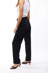 Pantalón de vestir negro de corte recto, con bolsillos laterales y presillas con hebillas decorativas en la cintura.