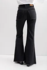 Pantalón de jean color crudo, de corte acampanado, tiro alto y terminación desflecada.