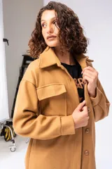 Tapado color beige con cuello solapa, corte recto, largo hasta la rodilla y cinturón de lazo.