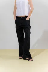 Pantalón de jean negro de lino rústico, con calce recto y tiro medio. Tiene bolsillos delanteros y traseros.